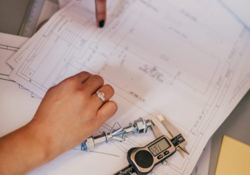 Engineer technician designing drawings mechanical parts engineering Engine.manufacturing factory Industry Industrial work project blueprints measuring bearings caliper tools. High quality photo